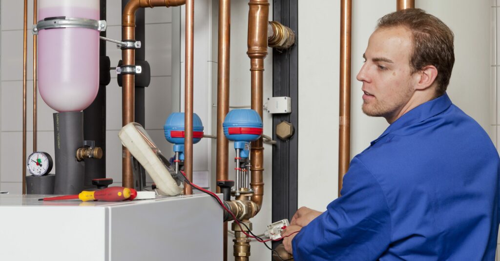 SHK-Anlagenmechaniker prüft die Geräteeinstellungen im Wartungsraum