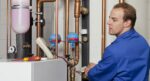 SHK-Meister prüft Heizungsanlage um Wohnhaus