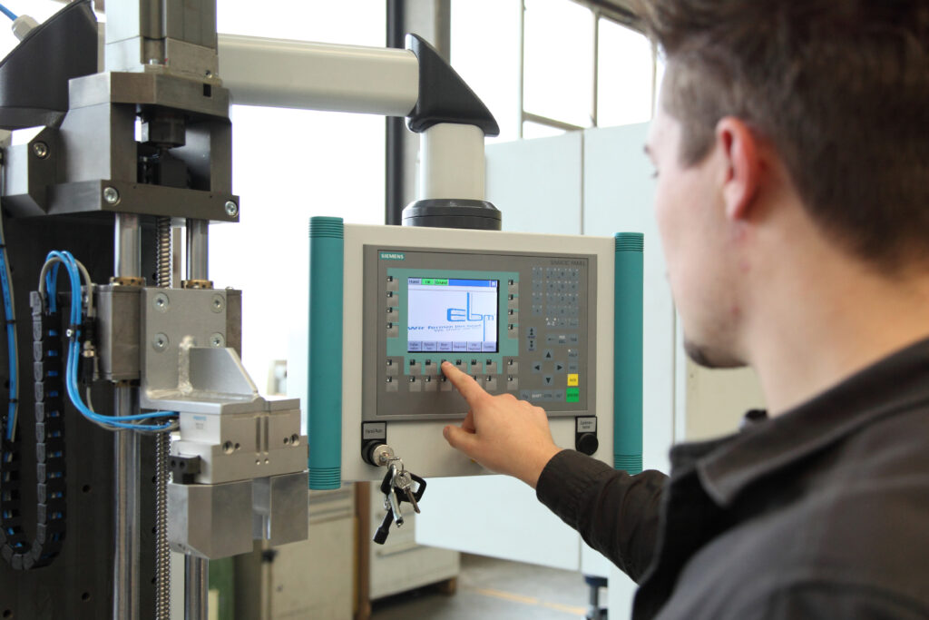 Teilnehmer eines Meisterkurses der Feinwerkmechanik an einer CNC Maschine