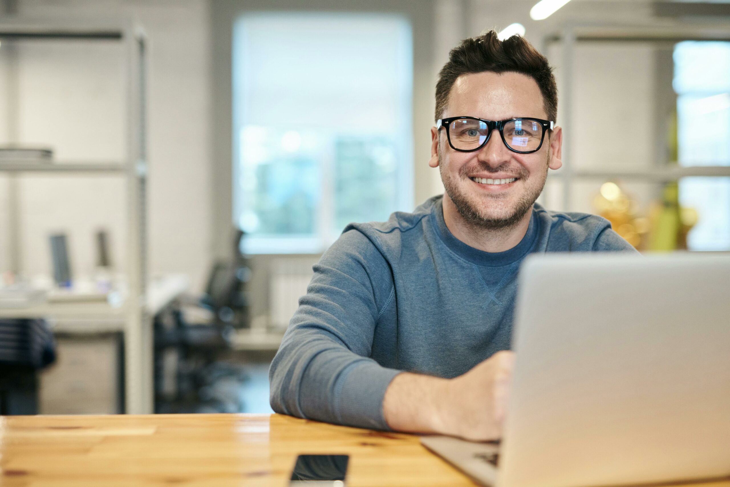 Junger Mann im Büro am Laptop